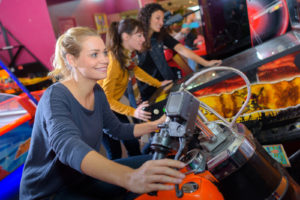 Indoor Portland Fun: Woman smiling on arcade motorcycle
